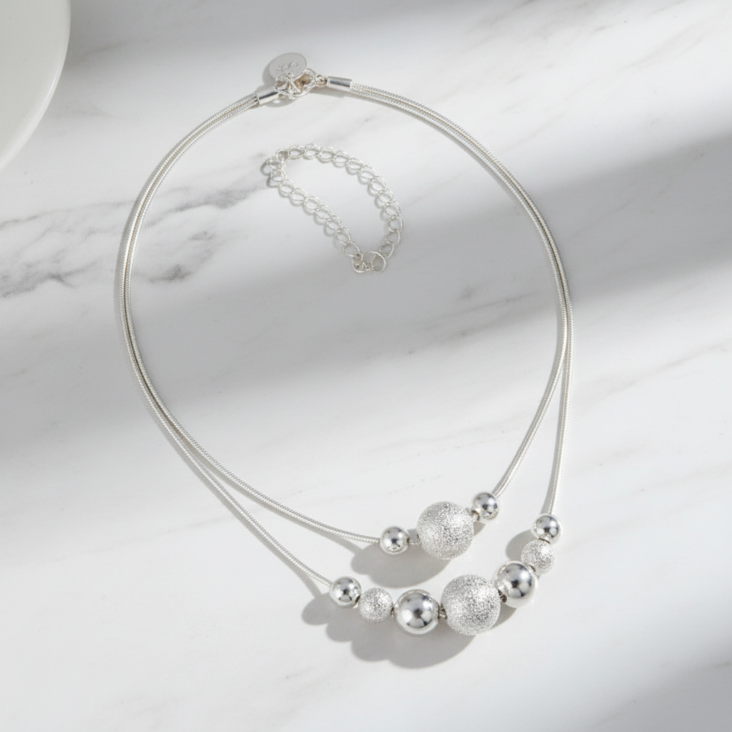 Silver Bead Chain Necklace flat lay on white marble